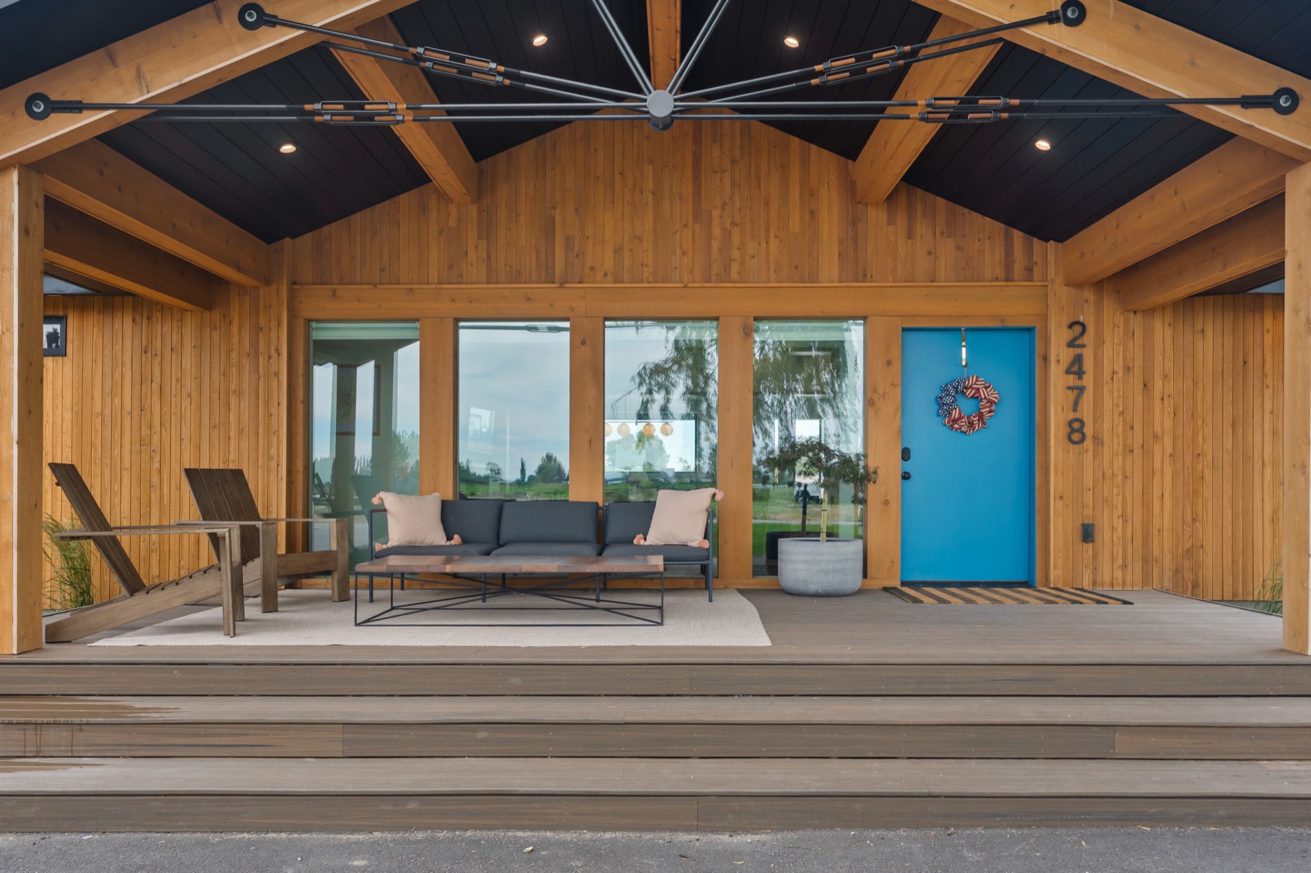 2478 W 4700 S — teal front door set in warm cedar beneath a timber-and-steel gable, Rexburg Idaho